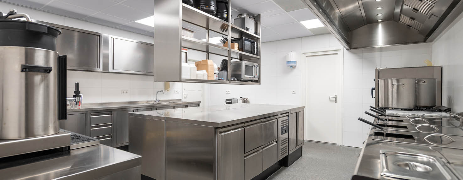 Moderne professionele keuken met rvs-werkplekken, kooklijn, wandkasten, afzuigkap en op maat gemaakte keukenopstellingen van Hakvoort Professional.