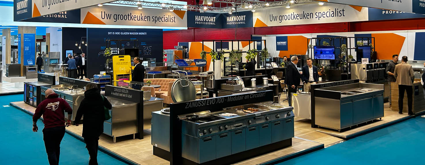 Beursstand van Hakvoort Professional op Horecava, met diverse grootkeukenopstellingen, apparatuur, live demo-units en medewerkers die bezoekers te woord staan.