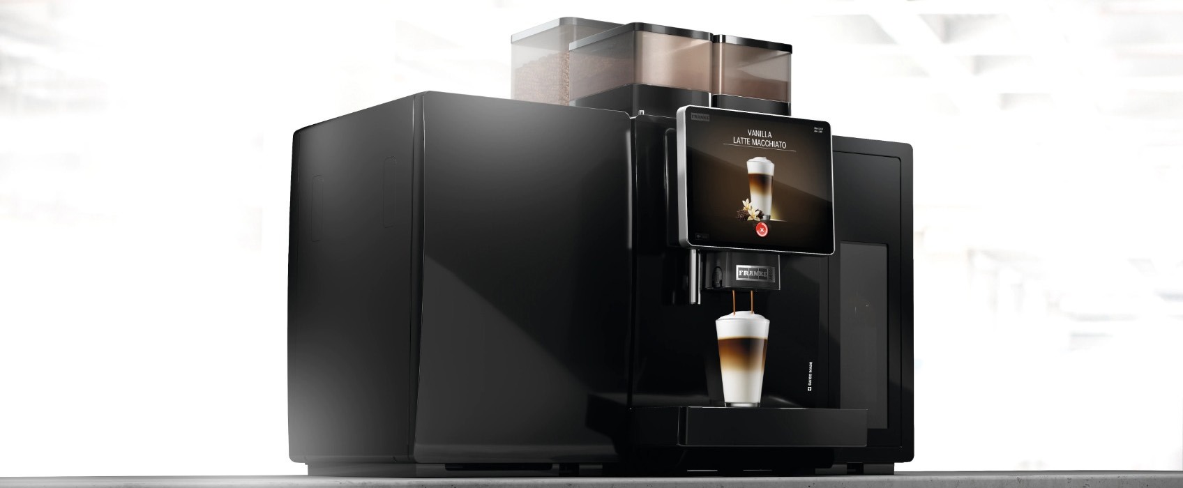 Professionele koffiemachine met touchscreen die een latte macchiato bereidt in een glas onder de uitloop.
