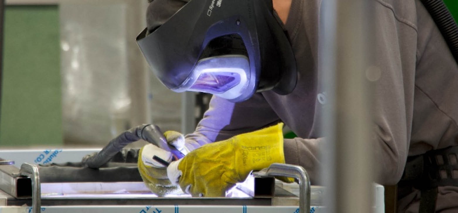 medewerker aan het lassen in de maatwerkfabriek