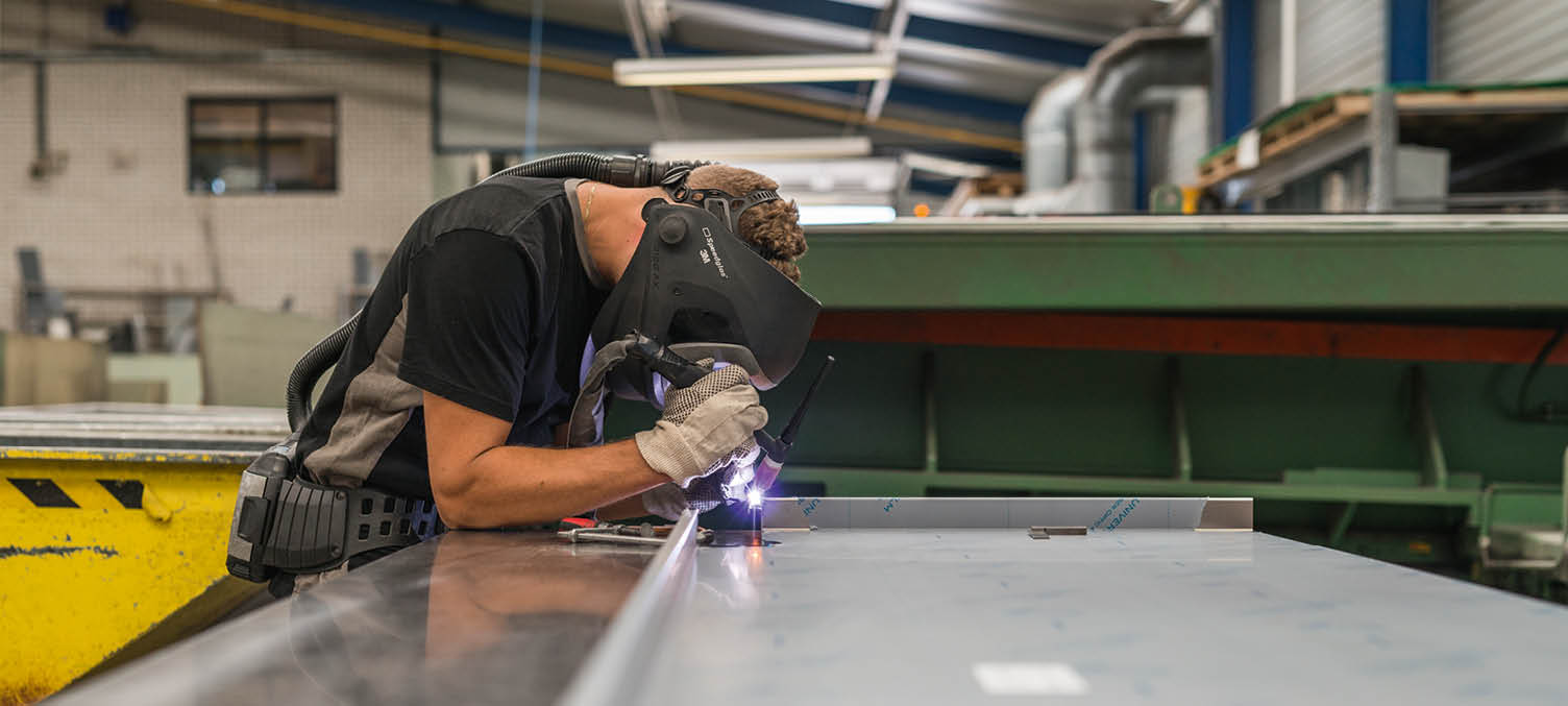 Medewerker maatwerkfabriek die aan het lassen is