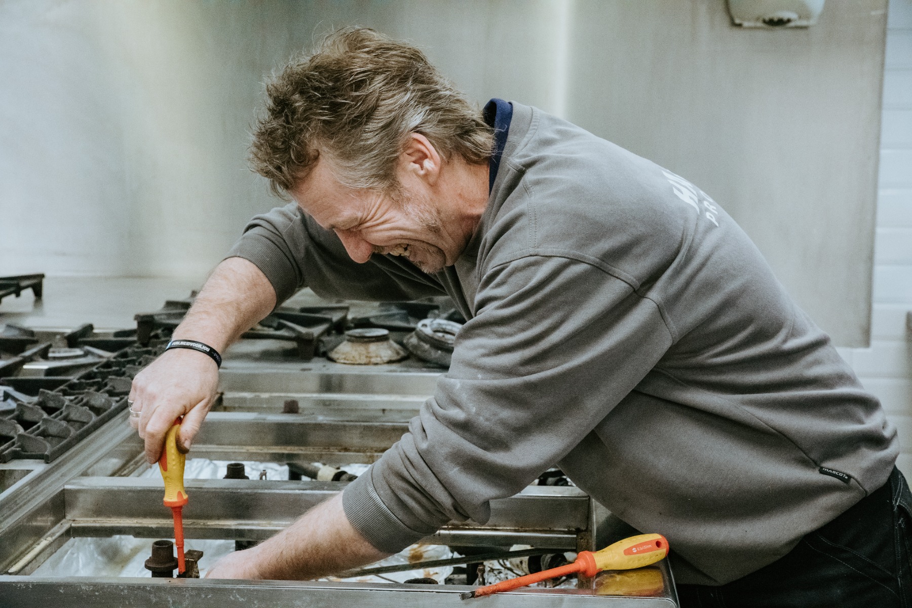 Vrolijke servicemonteur van Hakvoort Professional die een reparatie uitvoert