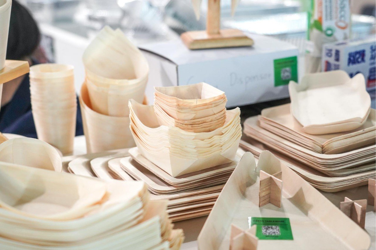 Stapel duurzame houten serveerbakjes en schalen op een beursstand