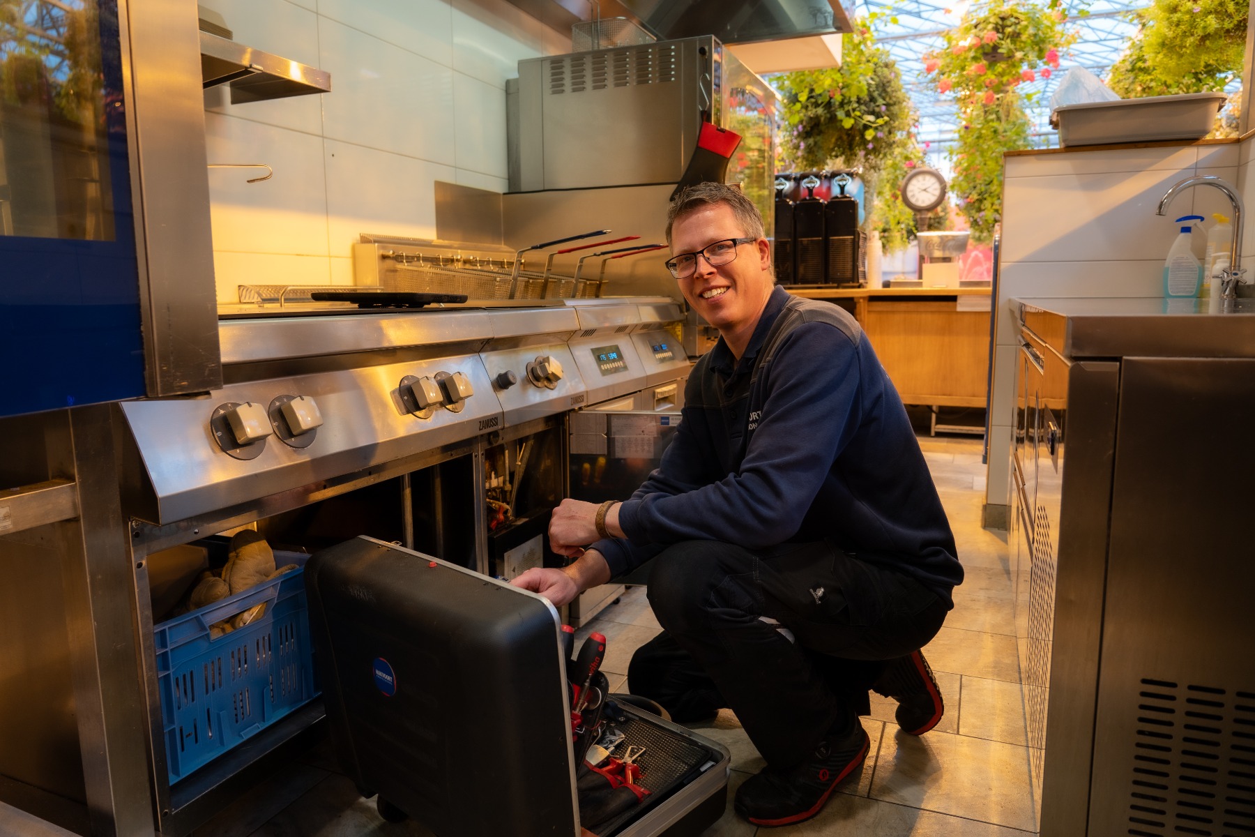 Monteur van Hakvoort Professional die bezig is met onderhoud aan een friteuse